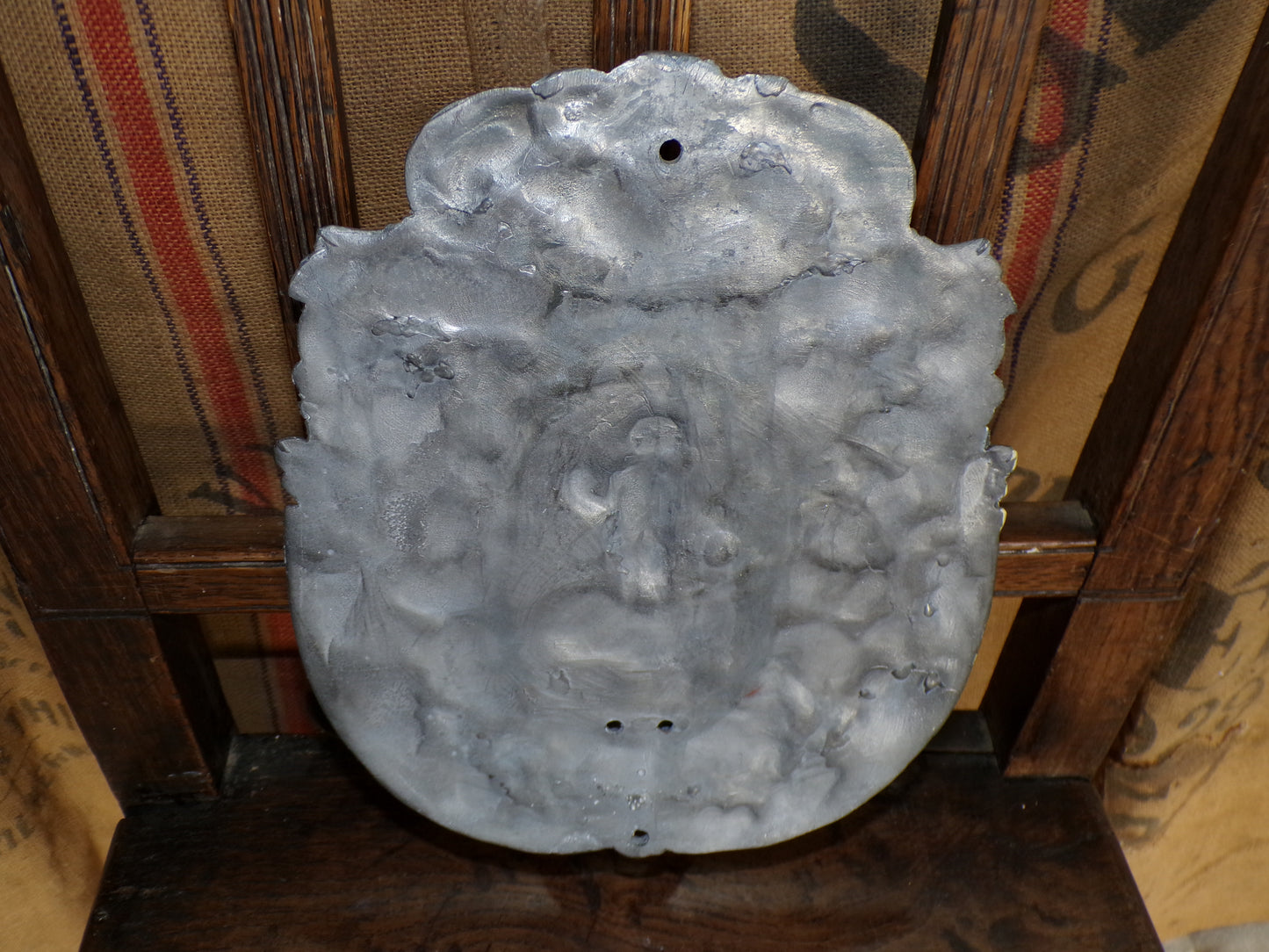 Early twentieth century/earlier hammered pewter sconce with cherub and light-rays detail.