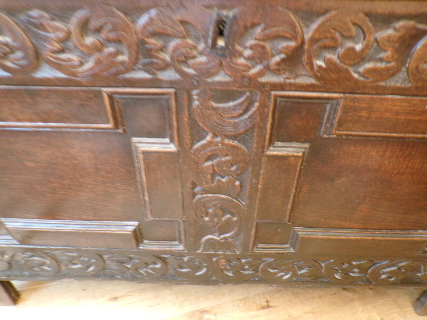 Seventeenth Century oak coffer with tulip and leafage carving surrounding two geometric mouldedpanels.