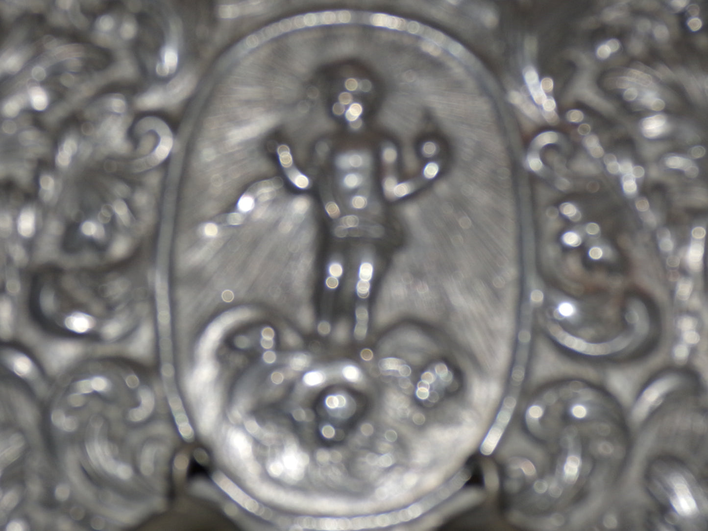 Early twentieth century/earlier hammered pewter sconce with cherub and light-rays detail.