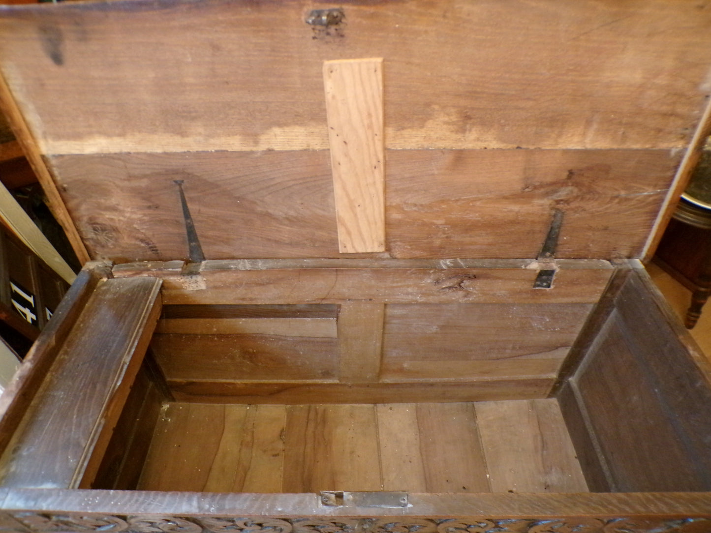 Seventeenth Century oak coffer with tulip and leafage carving surrounding two geometric mouldedpanels.