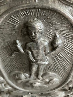 Early twentieth century/earlier hammered pewter sconce with cherub and light-rays detail.